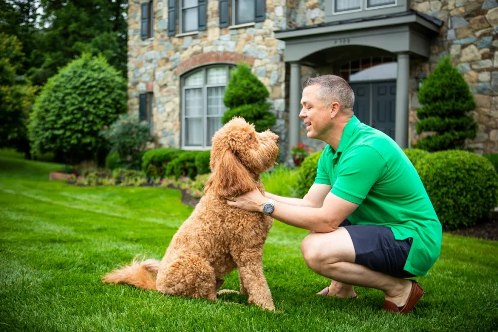 customer with his dog on the lawn in front of the house