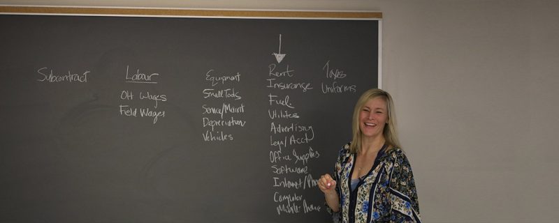 Janna Bradley teaching a class in front of a chalkboard