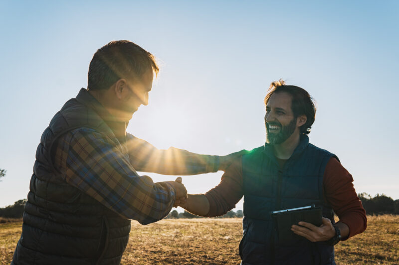 Two workers shaking hands outside