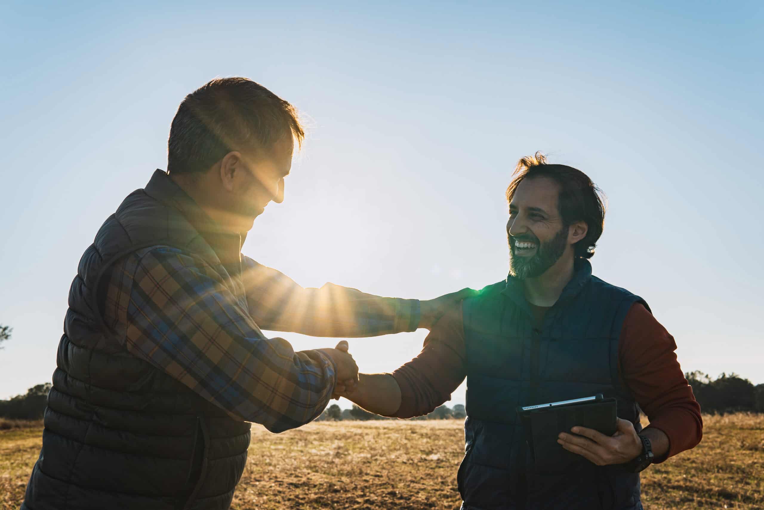Two workers shaking hands outside